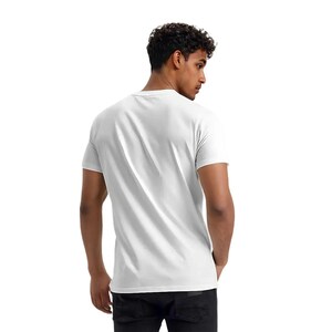 May include: A plain white crew neck t-shirt. The short-sleeved shirt is made of a soft material. The person is wearing black jeans. The background is white.