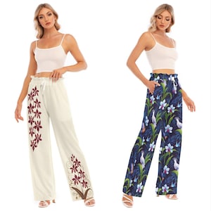 May include: Two women wearing white tank tops and wide-leg pants. One pair of pants is white with a red floral print, and the other pair is blue with a floral print.