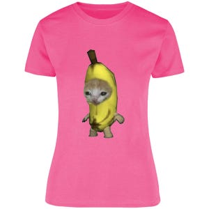 Puede incluir: Una camiseta rosa brillante con un gráfico de un gato disfrazado de plátano. El gato tiene una expresión triste. El disfraz de plátano es amarillo con un tallo marrón. La camiseta es de color sólido.