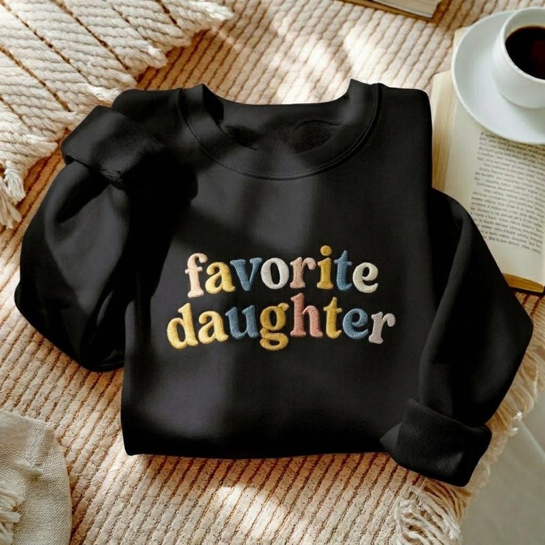 May include: A set of three ceramic mugs with a speckled, matte finish. The mugs are in cream, light grey, and dark grey. Each mug has a simple, minimalist design, ideal for coffee or tea.