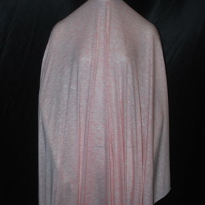 May include: A pale pink and white fabric with a subtle textured pattern. The fabric is draped over a mannequin.