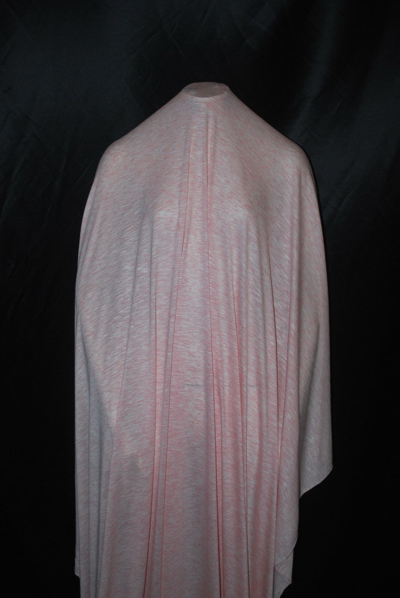 May include: A pale pink and white fabric with a subtle textured pattern. The fabric is draped over a mannequin.