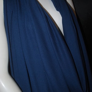 May include: A deep blue, ribbed fabric draped over a mannequin. The fabric is soft and has a slight sheen.