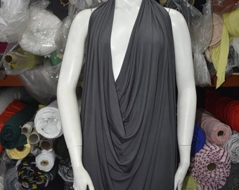 May include: A gray sleeveless draped top with a deep V-neckline. The top is made of a soft, stretchy fabric and is perfect for layering.