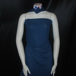 May include: A dark blue ribbed fabric draped over a headless mannequin. The fabric is smooth and has a slight sheen.
