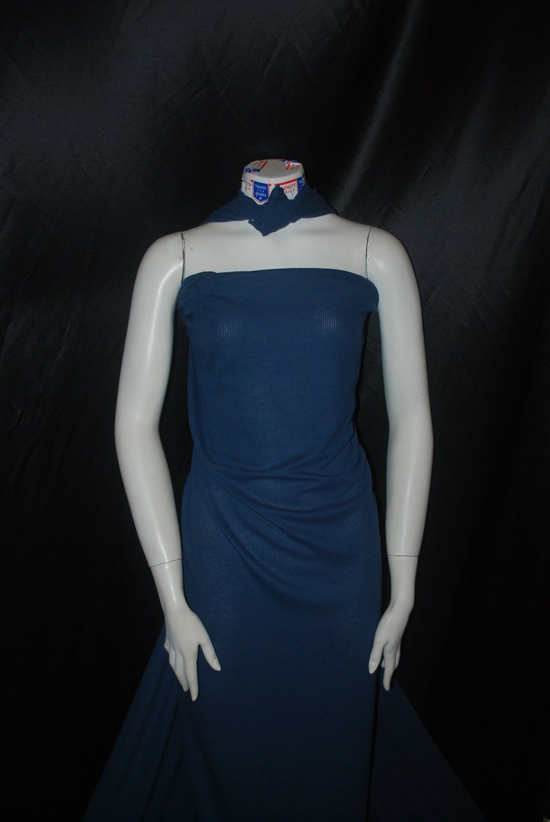 May include: A dark blue ribbed fabric draped over a headless mannequin. The fabric is smooth and has a slight sheen.