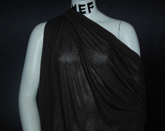 May include: A brown, drapey fabric with a soft, flowing texture. The fabric is shown draped over a mannequin.