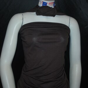 May include: A brown sleeveless top made of a soft, stretchy fabric. The top is fitted and has a cowl neck.