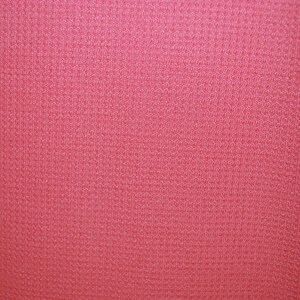 May include: A close-up of a pink fabric with a textured surface.