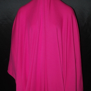 May include: A bright pink fabric draped over a mannequin. The fabric is smooth and has a slight sheen.