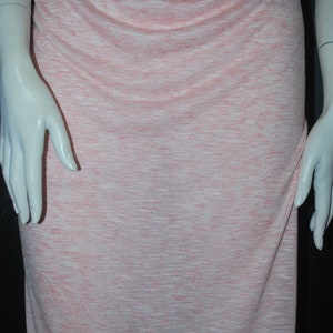 May include: A pink and white striped knit fabric with a subtle sheen. The fabric is soft and drapey, making it ideal for a variety of sewing projects.