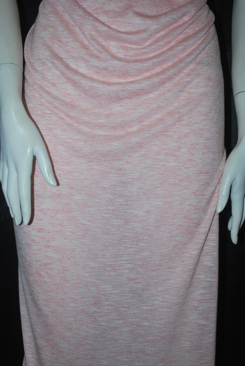 May include: A pink and white striped knit fabric with a subtle sheen. The fabric is soft and drapey, making it ideal for a variety of sewing projects.