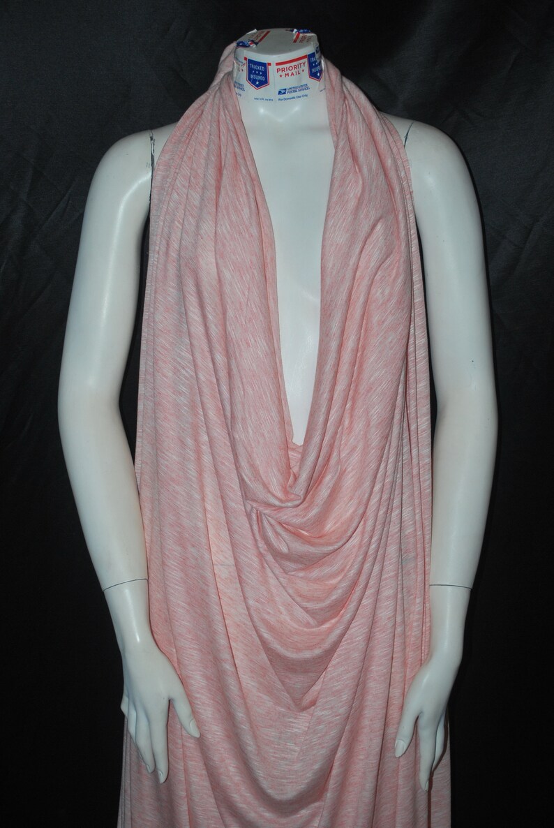 May include: A pink and white striped fabric draped over a mannequin. The fabric is soft and flowing, and it would be perfect for making a dress, skirt, or top.