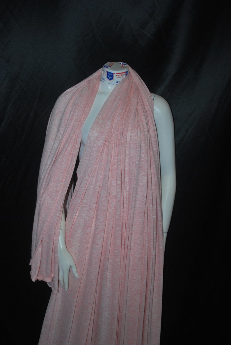 May include: A pink and white striped knit fabric draped over a mannequin. The fabric is soft and stretchy, and would be perfect for making a variety of garments.