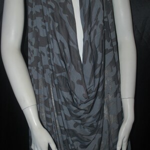 K&ouml;nnte beinhalten: Ein &auml;rmelloses Oberteil in Grau und Schwarz mit Camouflage-Muster und einem Cowl-Ausschnitt.