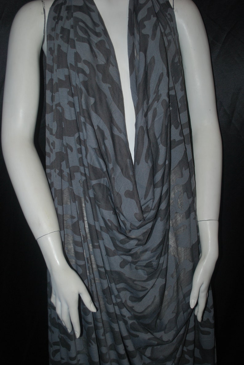 K&ouml;nnte beinhalten: Ein &auml;rmelloses Oberteil in Grau und Schwarz mit Camouflage-Muster und einem Cowl-Ausschnitt.