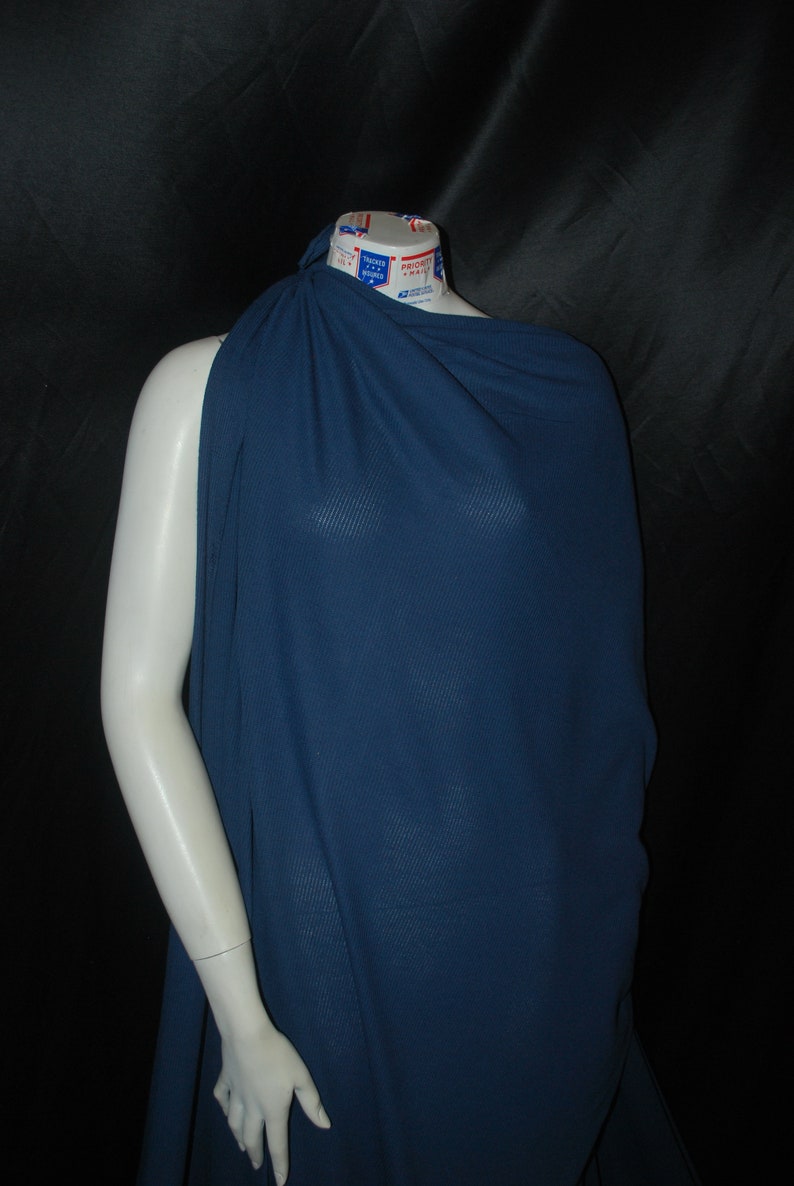 May include: A dark blue fabric draped over a mannequin. The fabric has a subtle ribbed texture.