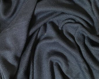 May include: Close-up of a dark blue ribbed fabric. The fabric is soft and has a subtle texture.