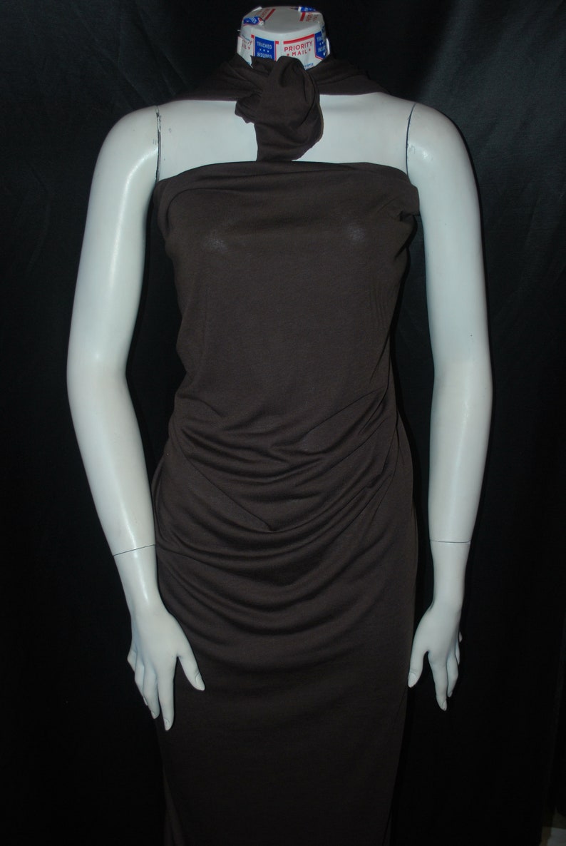 May include: A brown sleeveless dress with a cowl neck and a fitted silhouette. The dress is made of a soft, stretchy fabric and has a smooth, wrinkle-free finish.