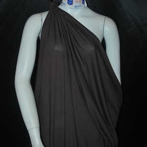 May include: A brown one-shoulder draped top made of a soft, flowing fabric. The top is draped over a white mannequin.