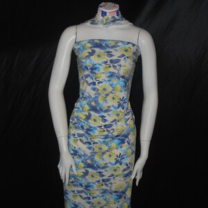 May include: A white dress with a blue and yellow floral print. The dress is sleeveless and has a straight neckline.