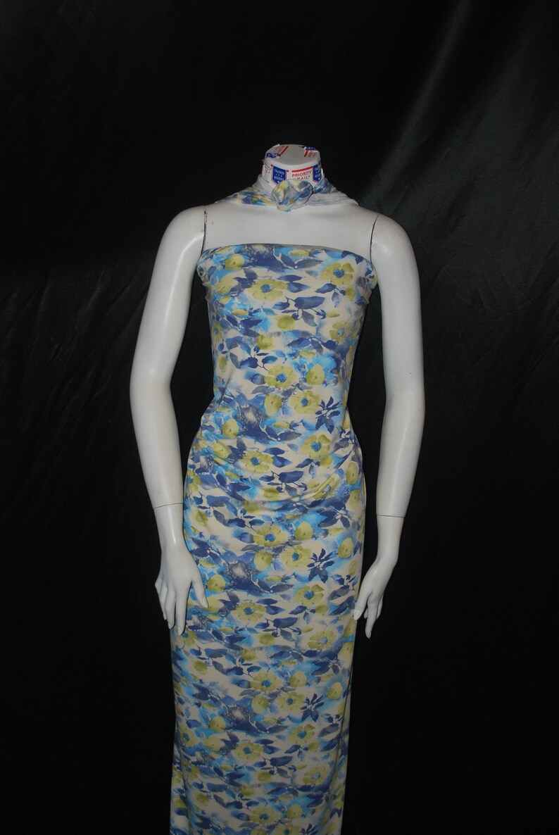 May include: A white dress with a blue and yellow floral print. The dress is sleeveless and has a straight neckline.