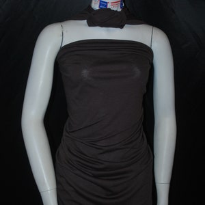 May include: A brown, strapless, fitted dress made of a soft, stretchy fabric. The dress is on a white mannequin.