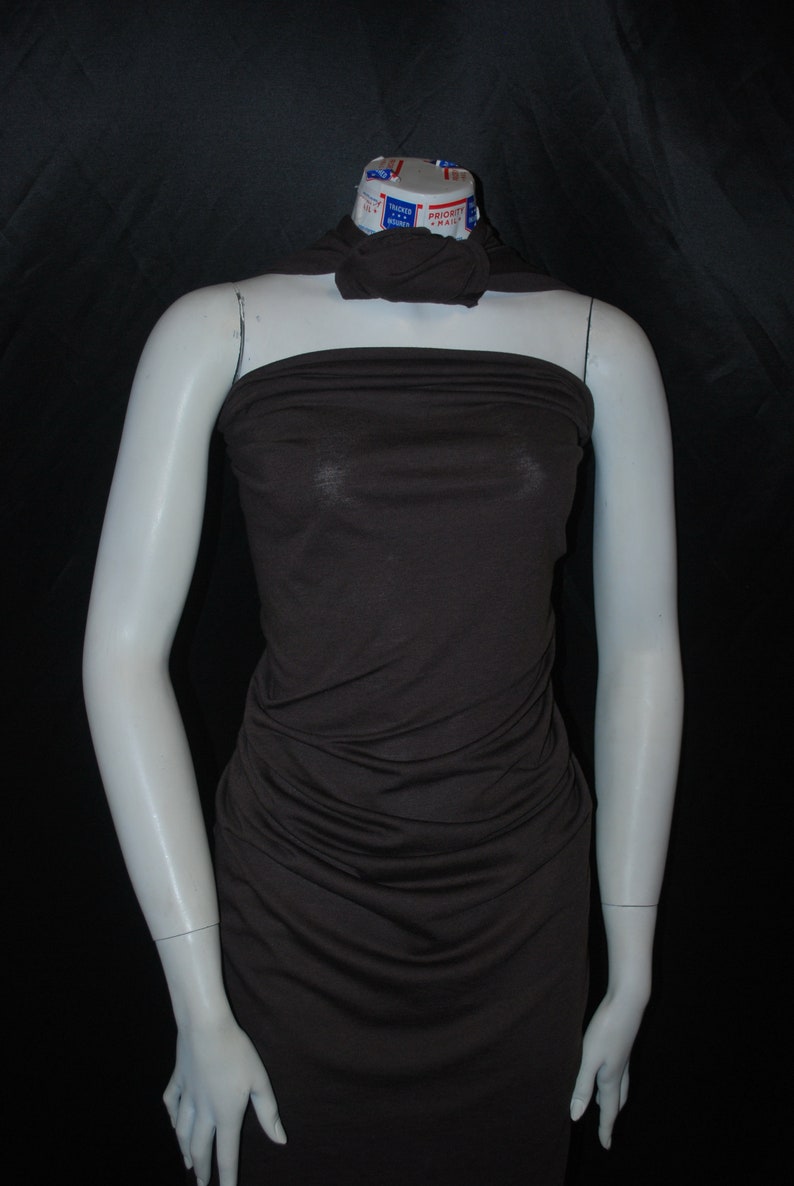 May include: A brown, strapless, fitted dress made of a soft, stretchy fabric. The dress is on a white mannequin.