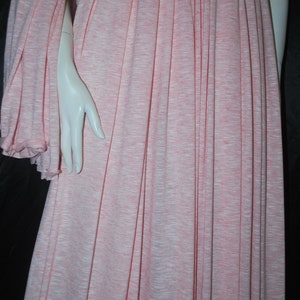 May include: A pink and white striped fabric with a soft, drapey texture. The fabric is pleated and has a subtle sheen.