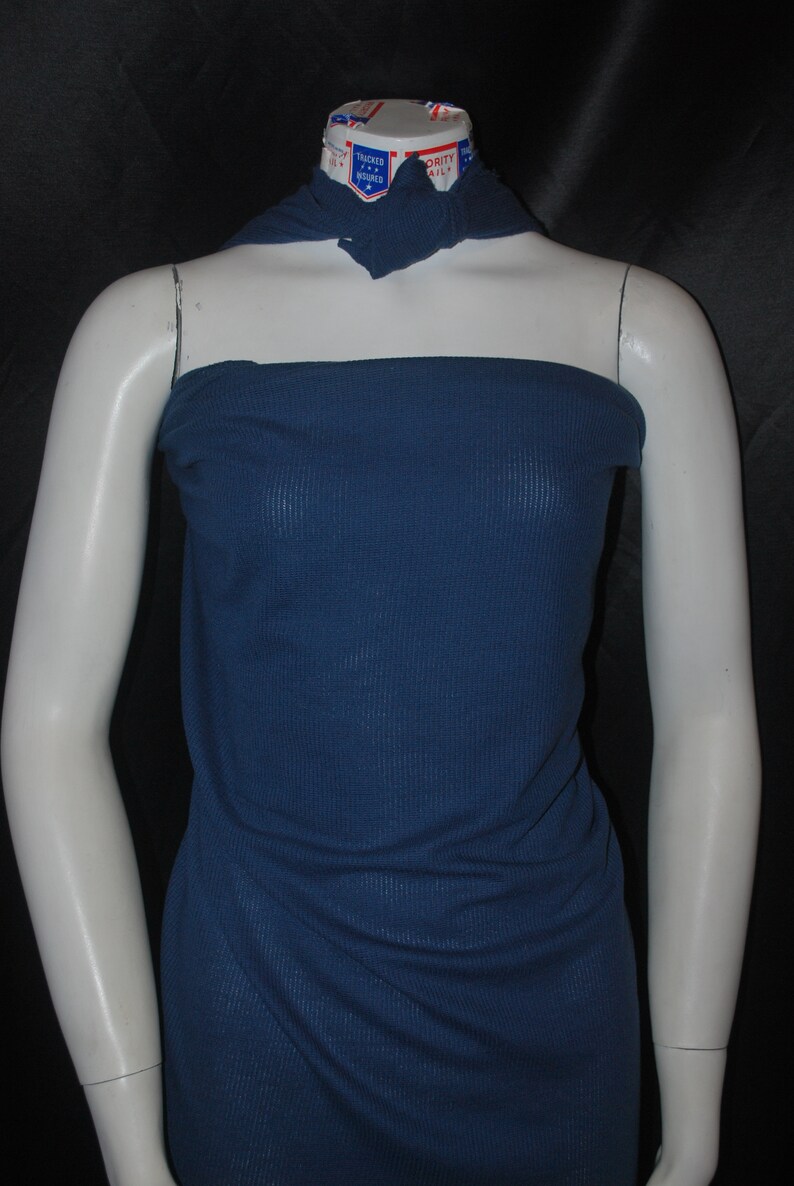 May include: A dark blue ribbed fabric swatch draped over a white mannequin torso. The fabric has a subtle texture and a smooth finish.
