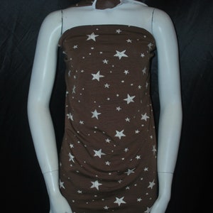 May include: Brown fabric with white stars printed on it. The fabric is draped over a white mannequin.