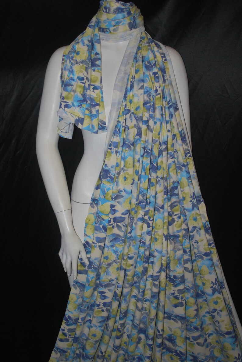 May include: A white, blue, and green floral print scarf. The scarf is made of a soft, lightweight fabric and is perfect for adding a touch of color to any outfit.