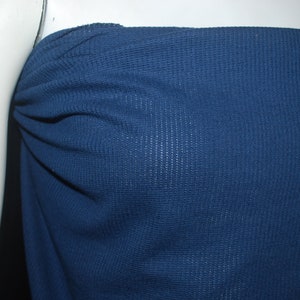 May include: A close-up of a dark blue waffle knit fabric. The fabric has a textured surface and is soft to the touch.