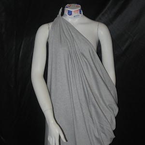 May include: A gray draped one-shoulder dress on a mannequin.