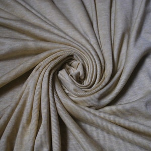 Puede incluir: Primer plano de una tela de punto de canal&eacute; beige con un patr&oacute;n de espiral.