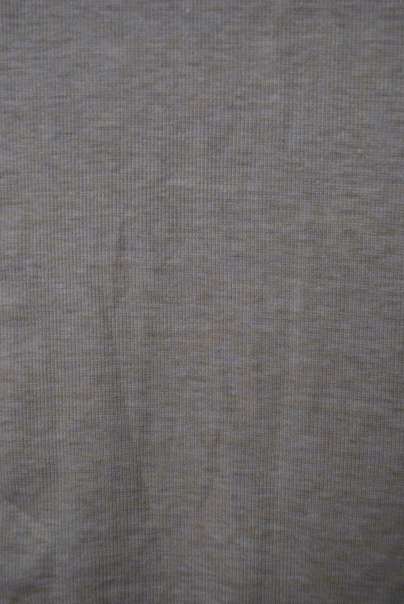 Puede incluir: Primer plano de una tela gris claro con una textura acanalada sutil.
