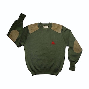 May include: Green sweater with suede shoulder patches and elbow patches. The sweater has a crew neck and a small red emblem on the chest. The sleeves are long and the overall style is classic and preppy.