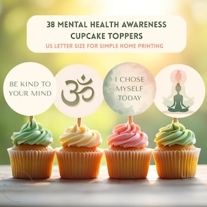 May include: Four cupcakes with green, yellow, and pink frosting, each topped with a circular Mental Health Awareness cupcake topper. The toppers feature text and symbols, including "Be Kind To Your Mind" and an Om symbol.