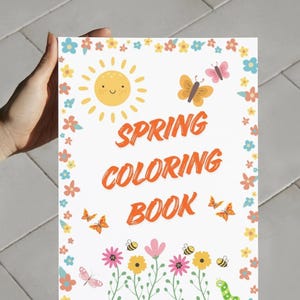 May include: A spring-themed coloring book with a white background. The cover features a smiling sun, butterflies, bees, flowers, and the words "SPRING COLORING BOOK" in orange. The book is held by a person.