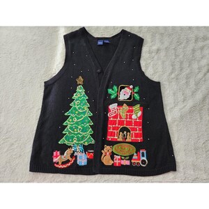 May include: A black sleeveless knit vest featuring a V-neckline and button-front closure. The front is decorated with embroidered and sequined holiday motifs, including a Christmas tree, a fireplace with stockings, a cat, and wrapped gifts.