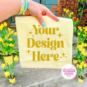 Banana Comfort Colors 1717 Mockup | Easter Spring Mockup | Hand Holding Folded Shirt | Yellow Shirt for Spring | Outdoor Floral Mockup