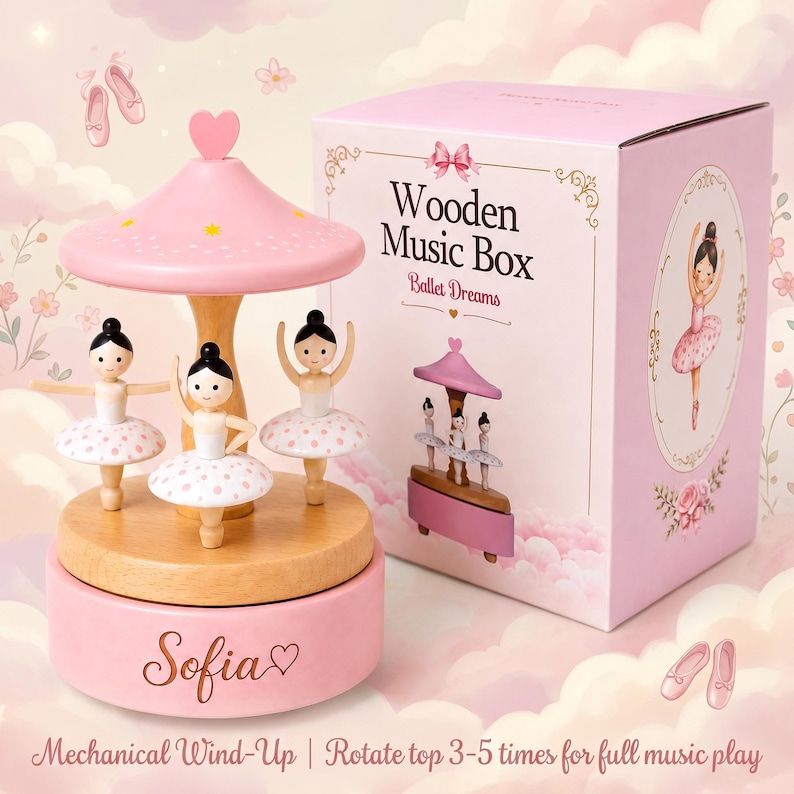 May include: A pink wooden music box featuring three ballerina figurines on a rotating base. The base is inscribed with the name Sofia and a heart. Beside it sits a matching pink box labeled Wooden Music Box Ballet Dreams.