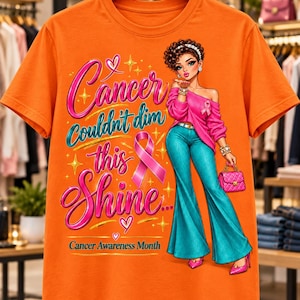 May include: An orange t-shirt featuring a graphic of a person in a pink top and teal flared pants, with the text "Cancer Couldn't dim this Shine" and "Cancer Awareness Month" alongside a pink ribbon, hearts, and gold star accents.