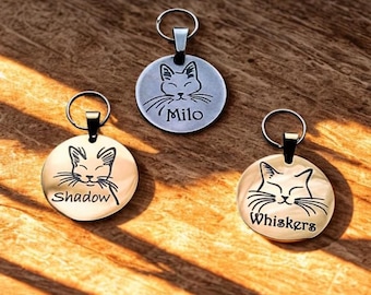 Peut inclure: Trois médailles rondes pour animaux de compagnie avec des visages de chats et des noms. Une médaille argentée avec "Milo", deux dorées avec "Shadow" et "Whiskers". Chaque médaille a une boucle métallique.