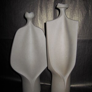 Peut inclure: Deux sculptures en c&eacute;ramique abstraites de couleur grise. Les sculptures sont hautes et fines avec une forme organique unique.