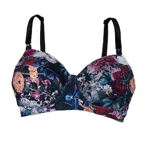 May include: A black floral print bra with adjustable straps. The bra has a dark green background with a variety of colourful flowers and leaves.