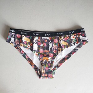 May include: Black and white dog print underwear with a floral pattern and the text "Eat, Sleep, Love, Repeat" on the waistband.