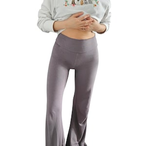May include: A pair of wide-leg pants in a dark gray color. The pants have a high waist and a relaxed fit.