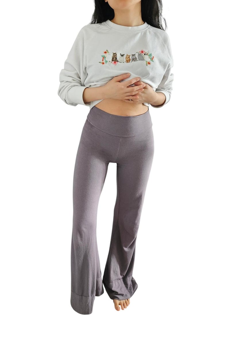 May include: A pair of wide-leg pants in a dark gray color. The pants have a high waist and a relaxed fit.