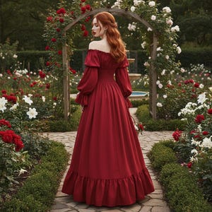 May include: A long, off-the-shoulder burgundy dress with long sleeves and a ruffled hem. The dress is worn in a garden setting with a stone pathway, surrounded by red and white roses, and a wooden archway.